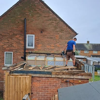Worker stripping old roof felt