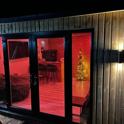 Garden room at night with black bifold doors
