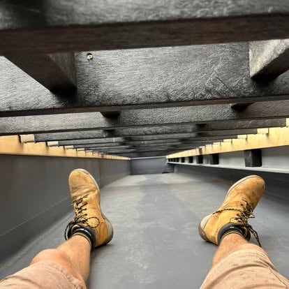 Worker under composite balcony decking frame