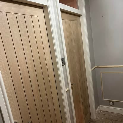 Two oak doors in hallway with panelling