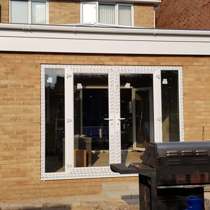 Sandy brick extension with white bifold doors