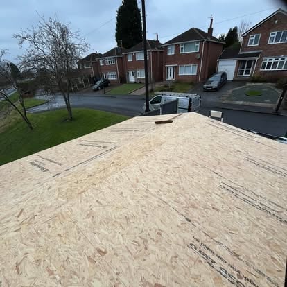 OSB deck being laid on large hipped roof suburban view