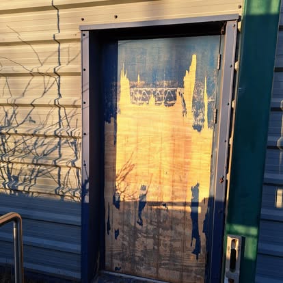 Door being fitted to horizontal metal-clad commercial unit