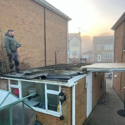 Worker on old deteriorating flat roof misty morning