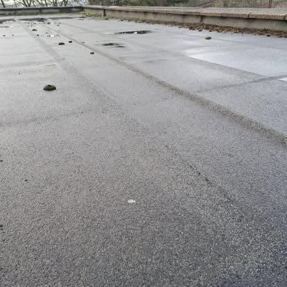 Old flat roof with standing water and puddles