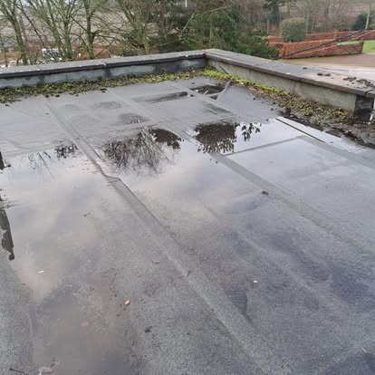 Old flat roof with puddles and moss