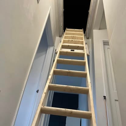 Loft ladder fully extended into loft opening