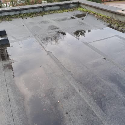 Old flat roof with standing water and puddles