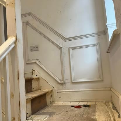 Staircase with wall panelling and tools during work