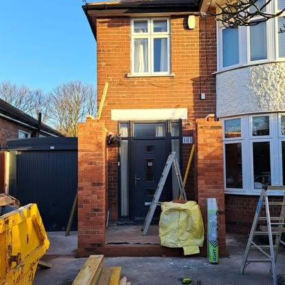 Brick porch construction with skip outside house 181