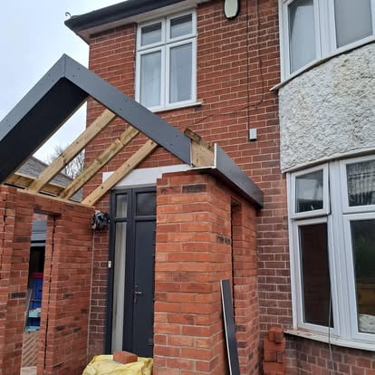 Brick porch timber rafters and grey panels being fitted