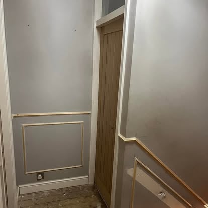 Staircase area with panelling and oak door being fitted