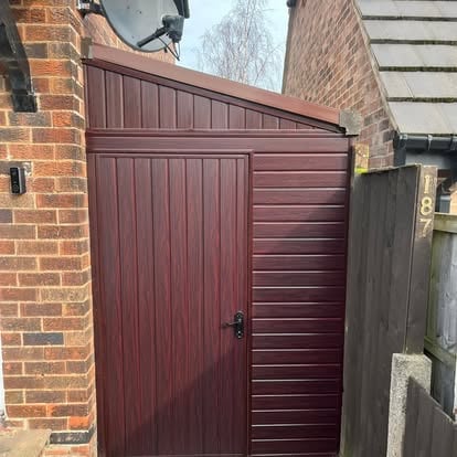 Completed dark brown lean-to door at side passage 187