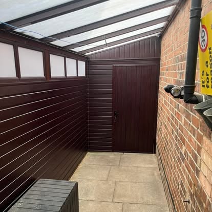 Dark brown lean-to interior near complete with door fitted
