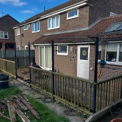 Old decking and black metal pergola before replacement