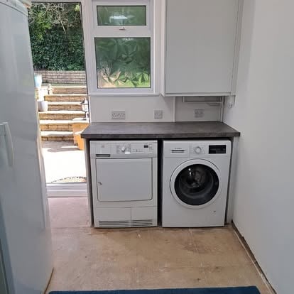Utility room with washing machine dryer and white cabinets