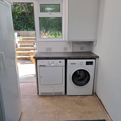 Utility room with boiler cupboard washing machine and dryer