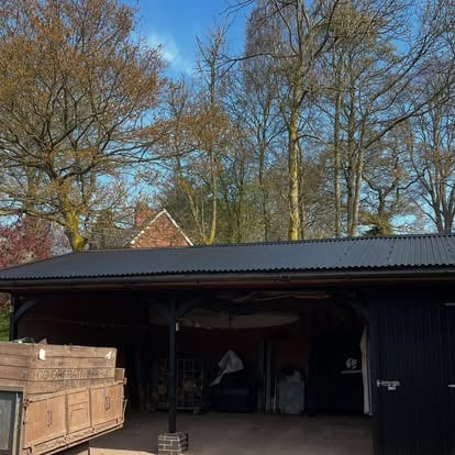 Large rural building with new black corrugated metal roof