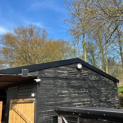 Completed black corrugated barn roof with new timber door