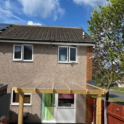 Polycarbonate roof being fitted on timber pergola over decking