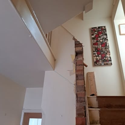 Interior staircase with exposed brick chimney breast opening