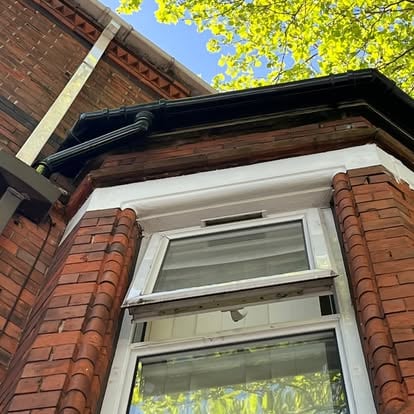 Victorian bay window white UPVC soffit and black guttering