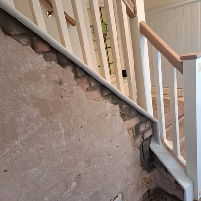 Oak handrail fitted on staircase with brick wall and stained glass
