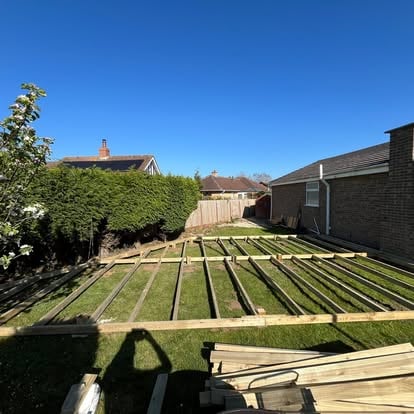 Deck joist grid laid across bungalow garden