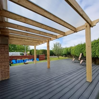 Grey composite deck under polycarbonate pergola roof