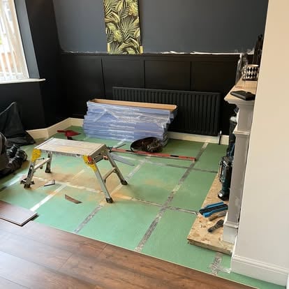 Dark navy room with floor underlay being prepared