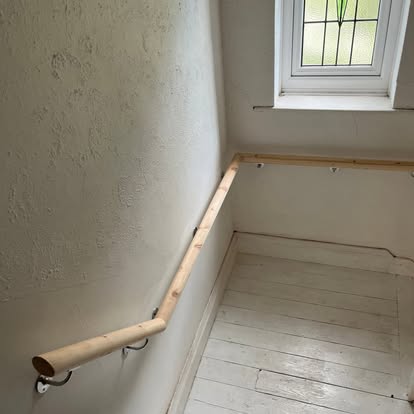 Pine handrail being fitted near leaded stair window
