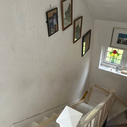 Staircase with stained glass window and framed photos