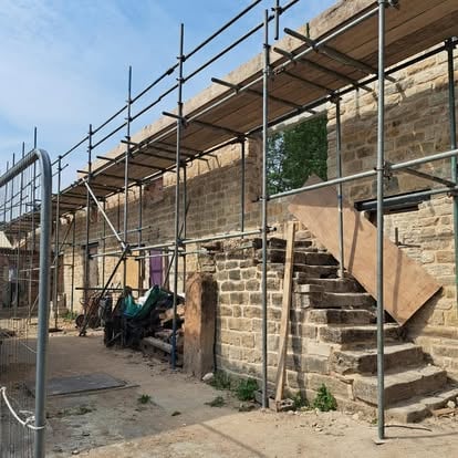 Historic stone building with scaffolding for roof repair