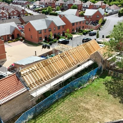 Old brick building with new timber rafters in housing estate