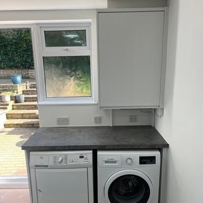 Grey shaker wall cabinet over washer and dryer