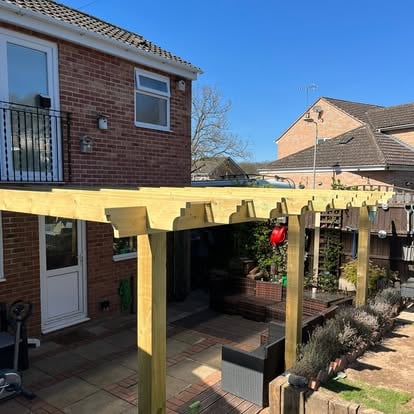 Timber pergola with scalloped rafter tails at brick house