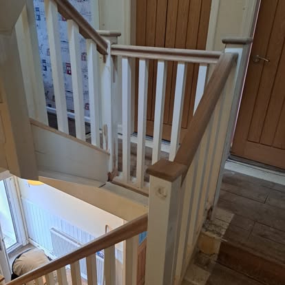New staircase with white newel posts and oak handrail