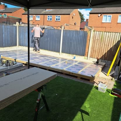 Composite decking boards being laid by worker