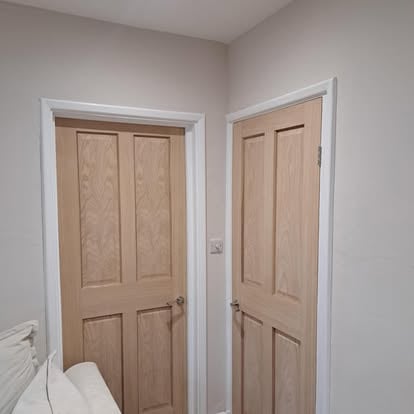 Two oak 4-panel doors in hallway corner