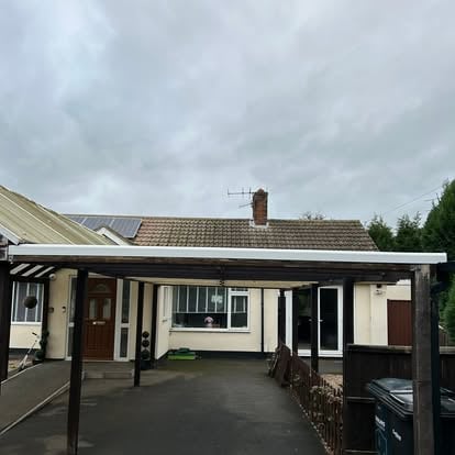 Bungalow with dark steel polycarbonate carport