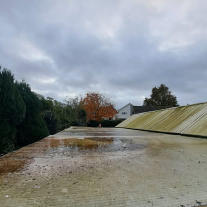 Old corrugated roof with puddles and algae