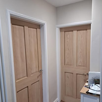Two oak 4-panel doors in corner room with carpet
