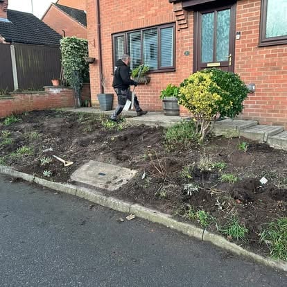 Worker clearing front garden before landscaping