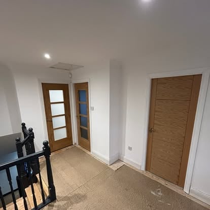 Hallway with oak glazed doors and black stair balustrade
